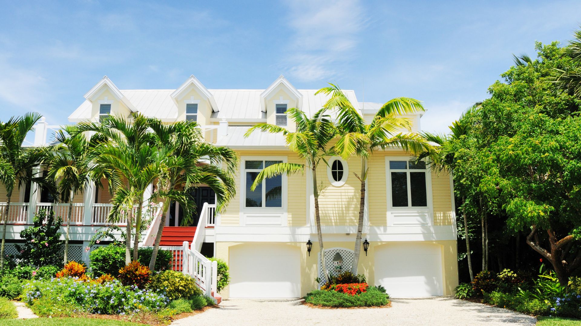 A yellow house with palm trees in front of it