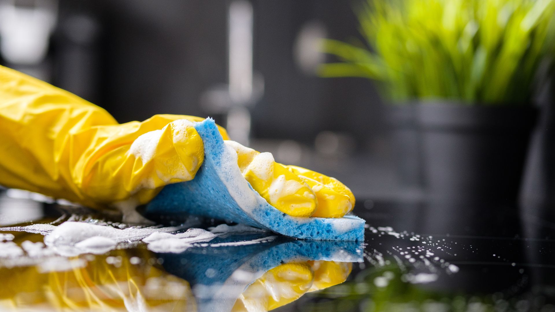 A yellow and blue cleaning glove laying on top of a table